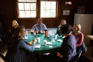 Attendees seated at a round table for coffee and social discussion.