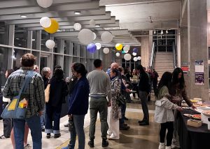Winter Welcome attendees enjoying appetizers and conversation in the fisheries lobby. People congregating in groups, standing throughout the lobby.
