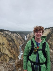 Photo of Dana smiling on a hike with a gorge in the background
