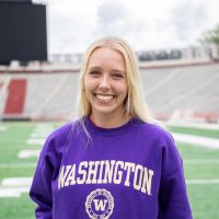 Headshot of Reese smiling for the camera. She is wearing a purple UW sweatshirt