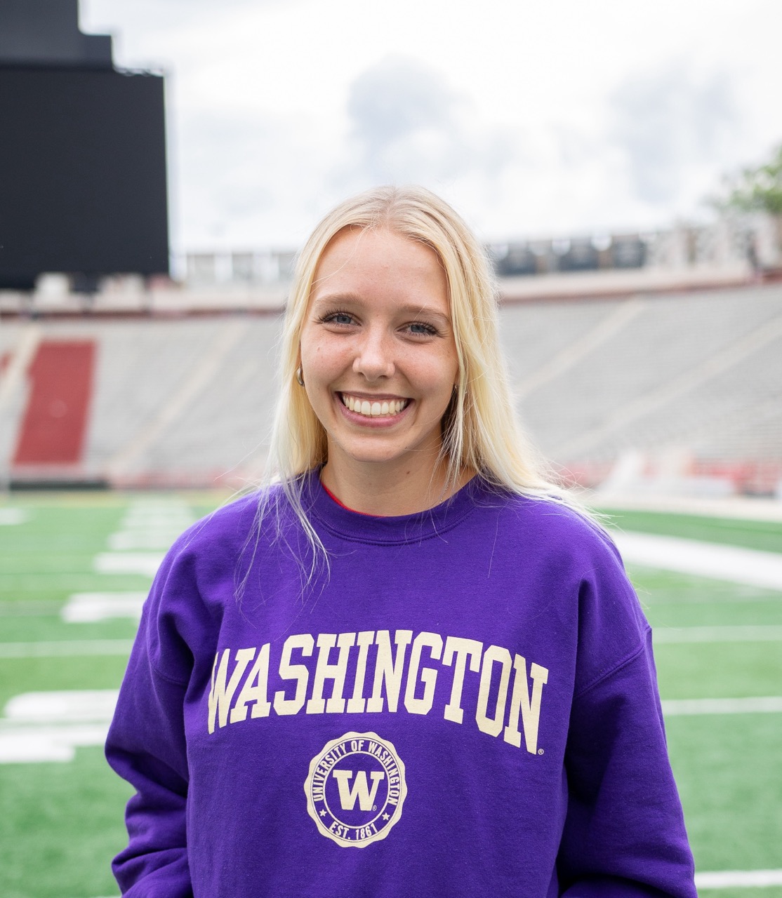 Headshot of Reese smiling for the camera. She is wearing a purple UW sweatshirt