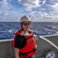 Photo of Randie on a boat wearing a life jacket and helmet