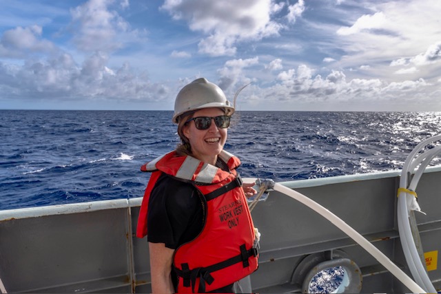 Photo of Randie on a boat wearing a life jacket and helmet