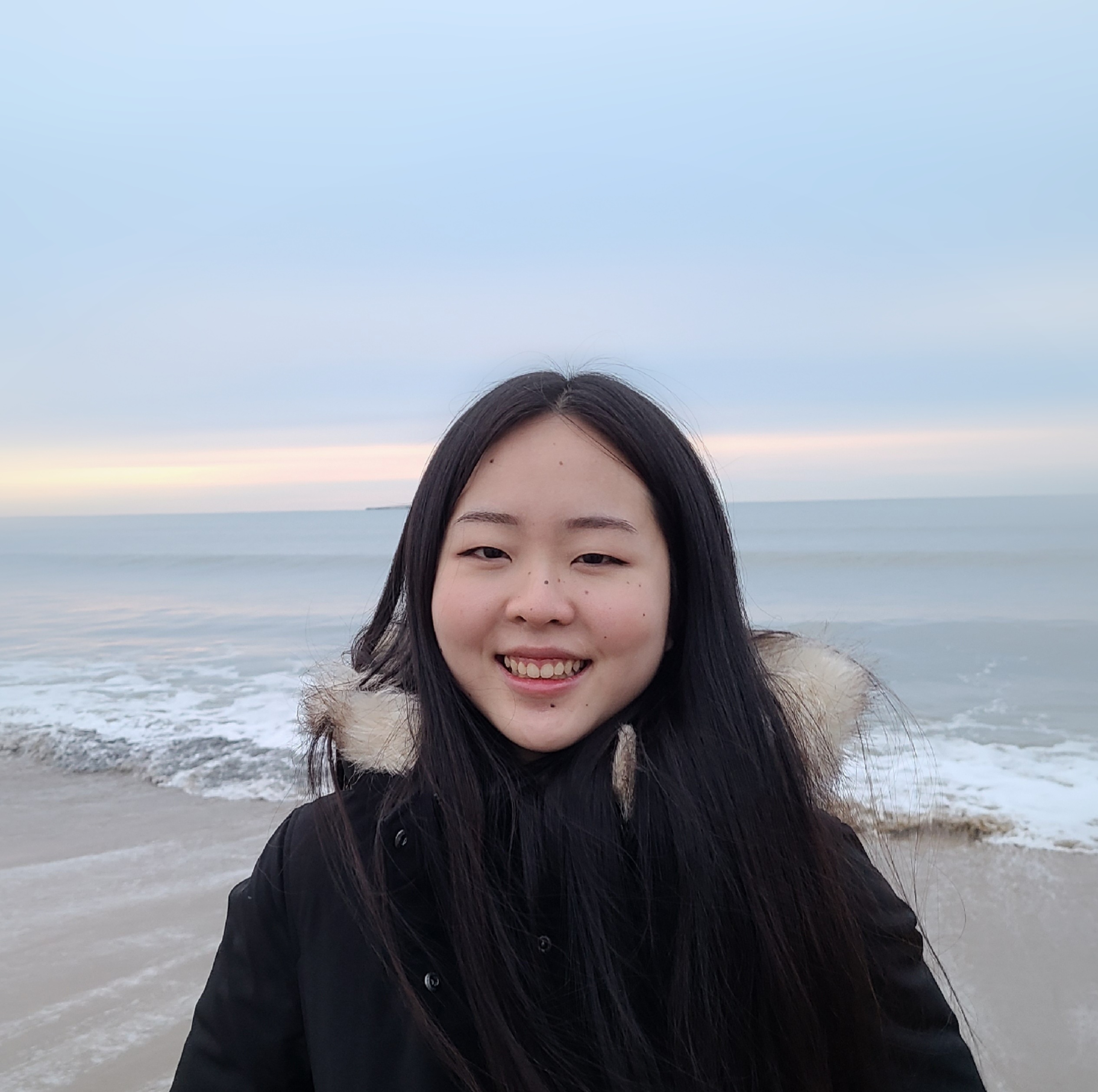 Headshot photo os Lily smiling at the beach