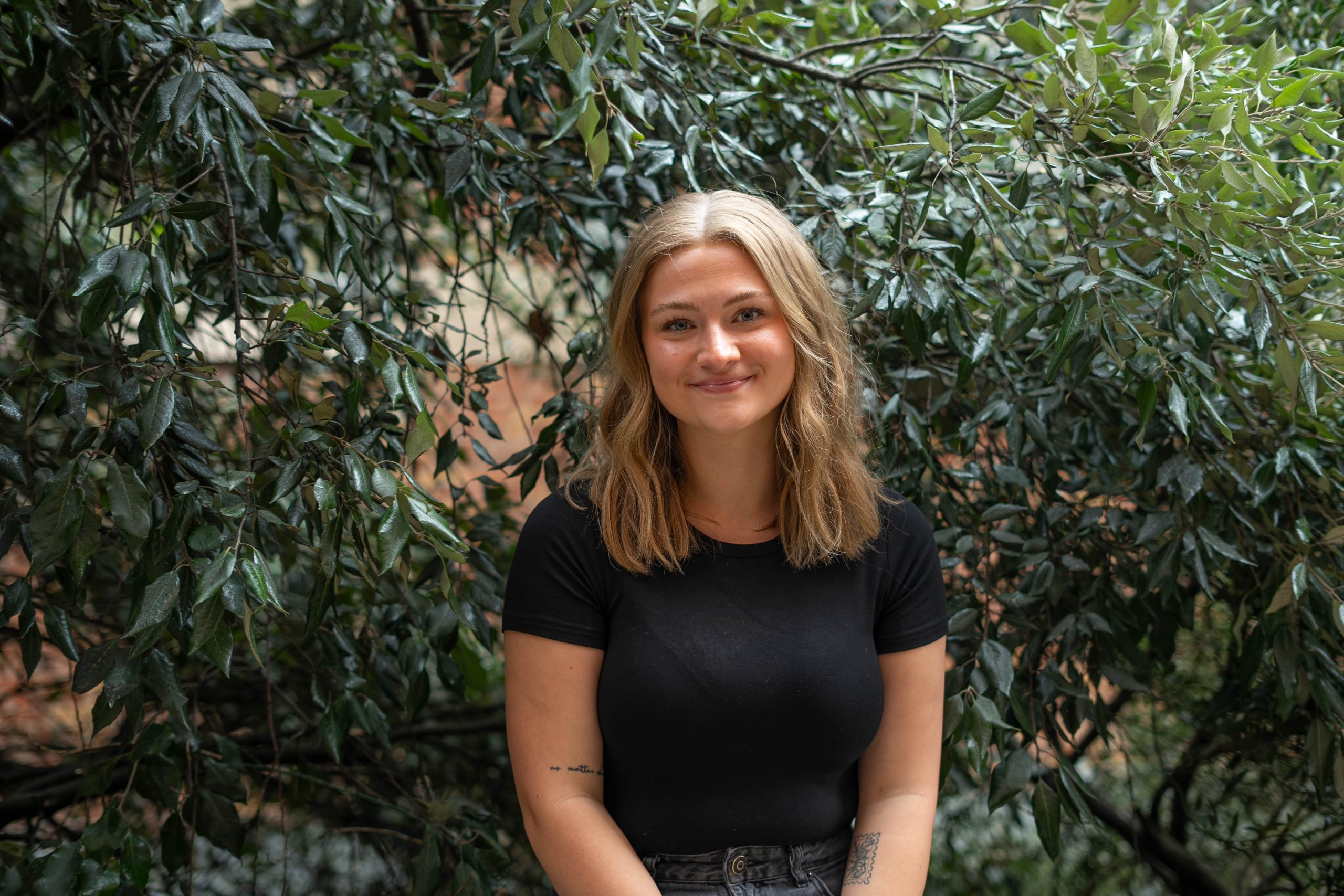 Hannah McKinley headshot smiling in front of vegetation
