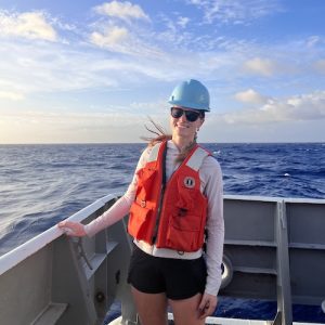 Elise on the R/V Thomas G Thompson in a life vest and hard hat.