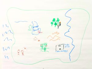 A rectangular outline with marker drawings of the Puget Sound, stick figures outside a hospital, orchards, clean energy powering a data center, and a campfire.