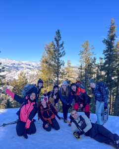 A group of hikers smiling at the top of a snowy hike