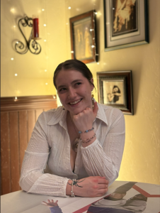 woman smiling with head sitting on hand in a lit room