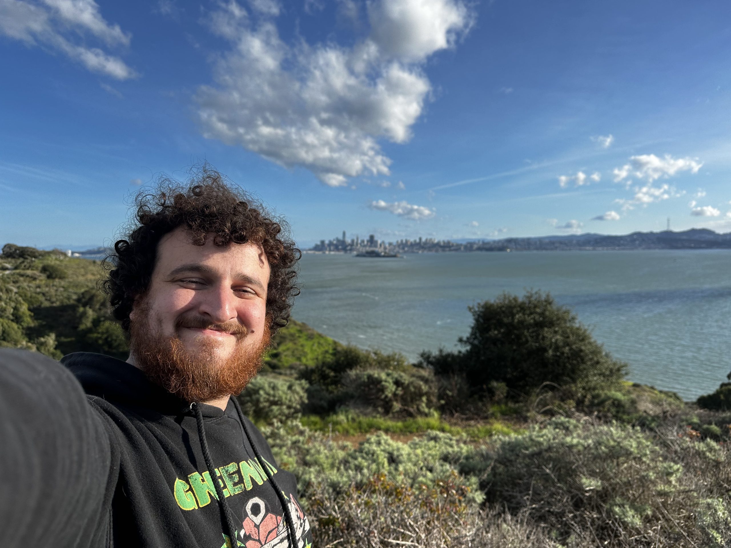 Dylan Arius Harootunian selfie smiling in front of large body of water